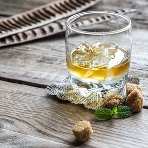 Glass of rum on the wooden background