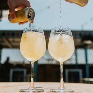pouring two cold drinks on a rooftop terrace