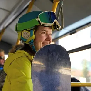 Joyful Snowboarder Riding Bus to Slopes