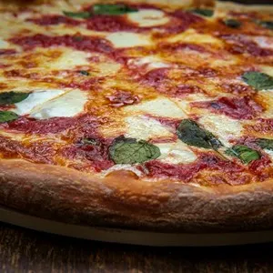 New York style Margherita pizza with fresh mozzarella and basil leaves