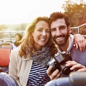 portrait of couple enjoying holiday vacation sightseeing bus open top tour