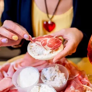 Traditional italian appetizer with proscioutto, mortadella sausage, cheese, bread and aperol spritz drink on the wooden board.