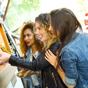 Three young women eating at an outdoor market - San Antonio, Texas