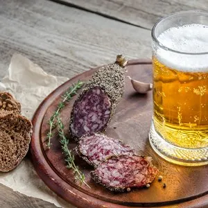 Slices of french Saucisson sausage with glass of beer