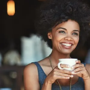 woman holding a drink, hot chocolate or coffee at a cafe