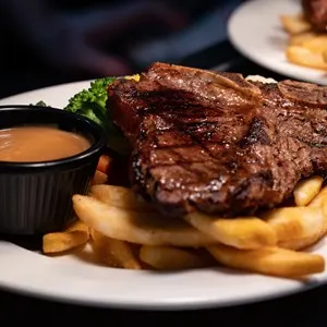 T-bone steak served with chips, vegetables and gravy