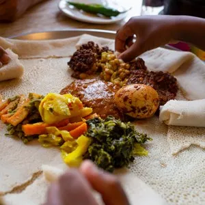 Sharing a vegetarian injera meal, with shiro, lentils, egg and a variety of vegetables