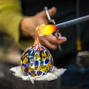 A Glass Blower Shaping Molten Glass into a Piece of Art